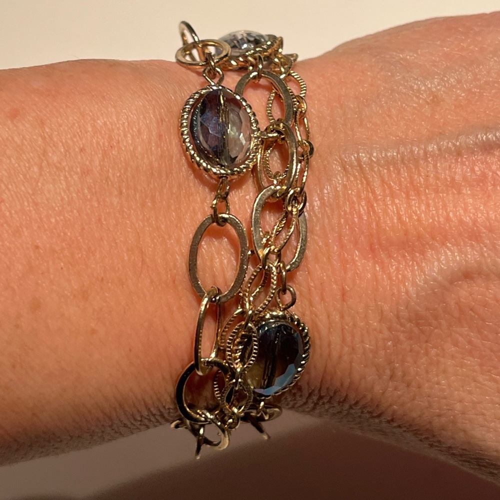 antique gold tone four strand bracelet with oval stones on two strands.
